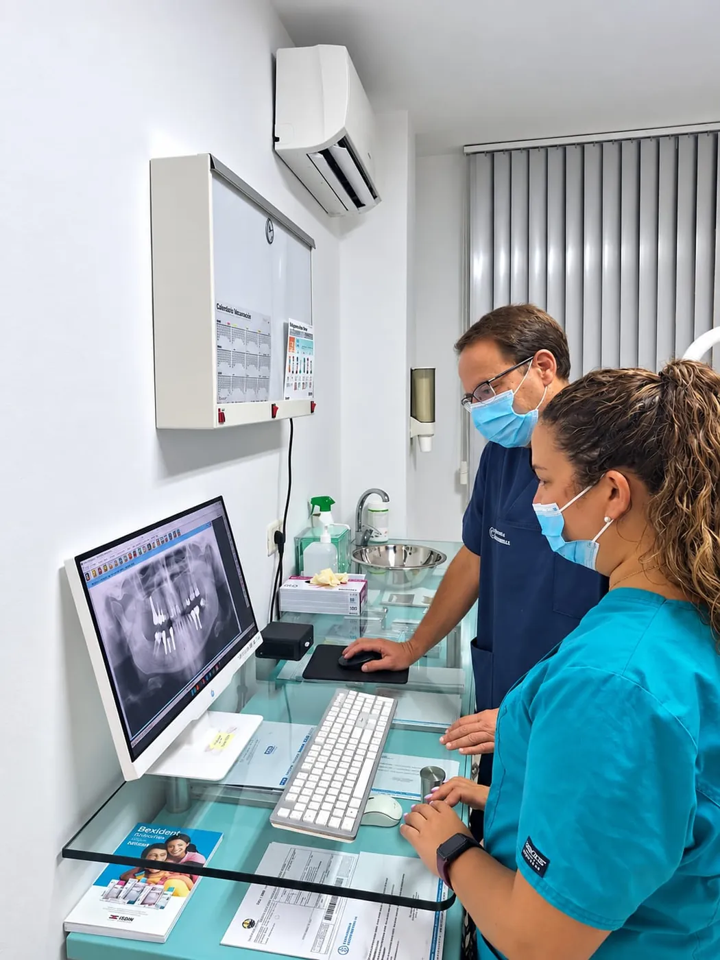 Dos profesionales de Clínica Scherba revisando una radiografía dental en pantalla